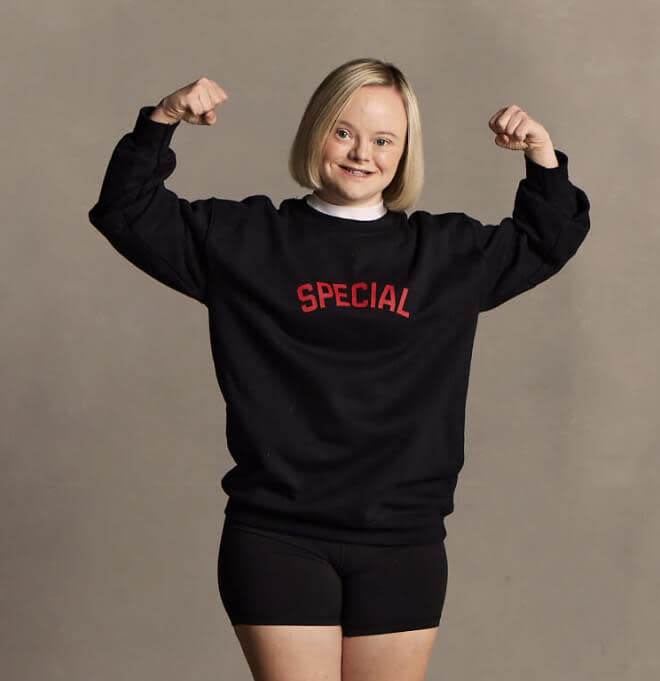 Special Olympics athlete Madison "Maddog" Madory flexing and smiling in a Special Olympics shirt