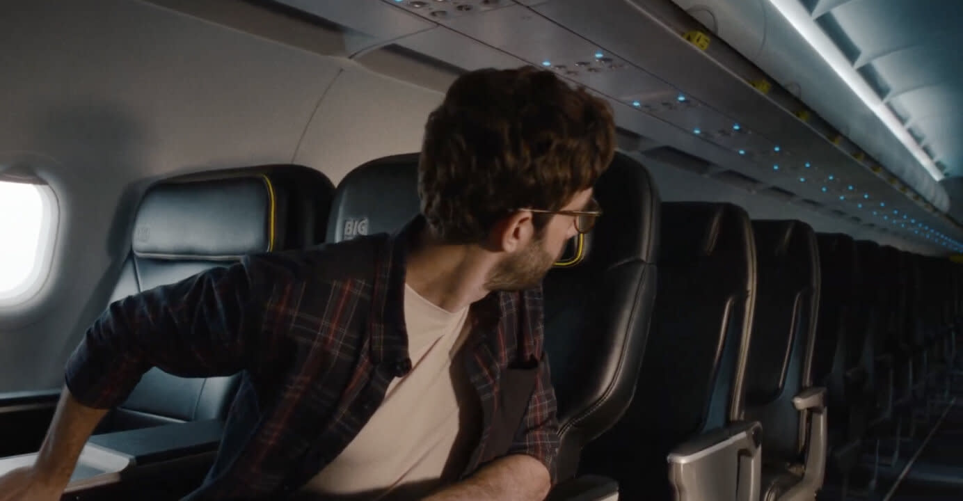 Man looking down the center aisle on a Spirit airplane