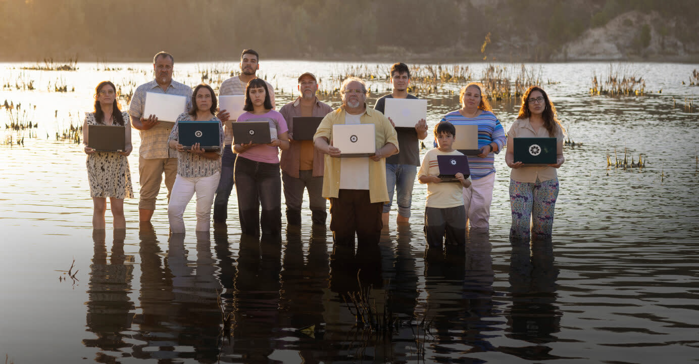 Citizens of a Chilean town standing in water holding laptops
