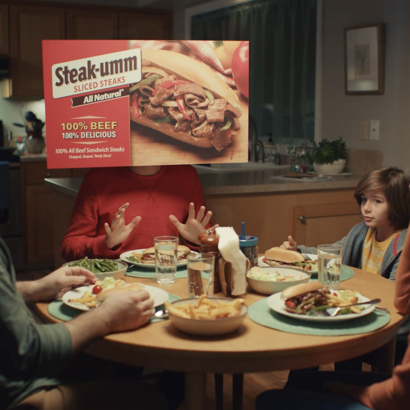 Steak-Umm 'Umm...' campaign promo image of a family eating dinner around the table