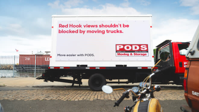 A Pods container in Red Hook with a quirky AI generated phrase about moving trucks blocking views