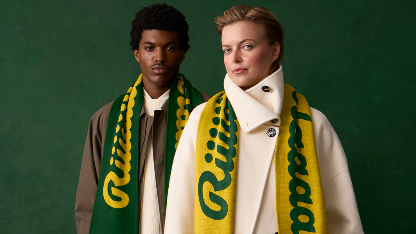 Man and woman staring into the camera while wearing the green and yellow Ricola scarves