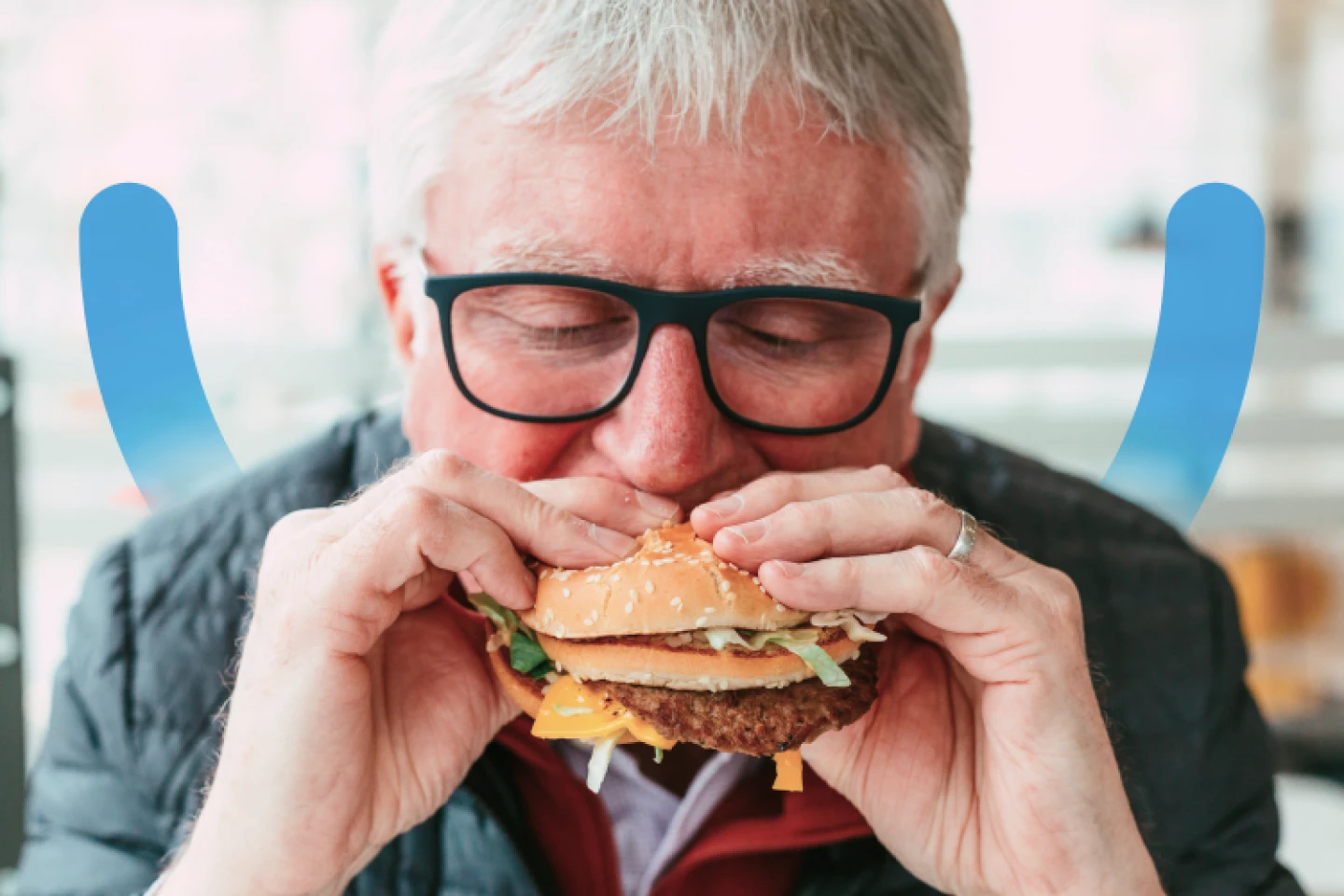 An Aspen Dental implants patient bites into a burger. 