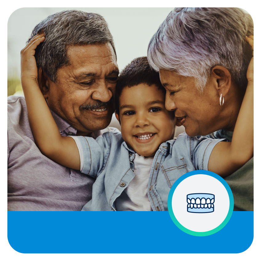 Un niño sonriendo dando un abrazo a sus abuelos con cabello gris.