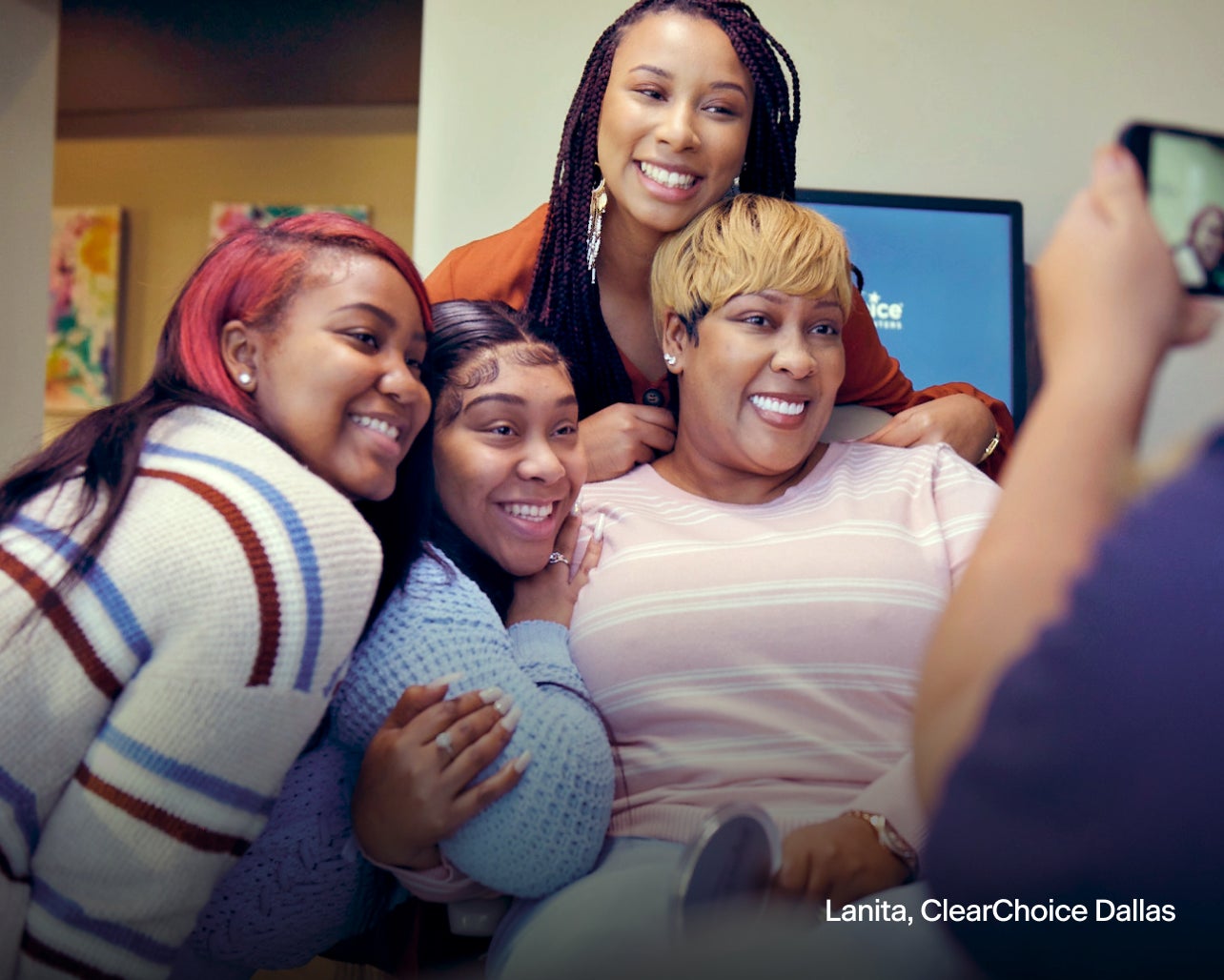 An image of Lanita, a ClearChoice dental implant patient from Dallas, taking a picture with her family after her dental implant procedure.