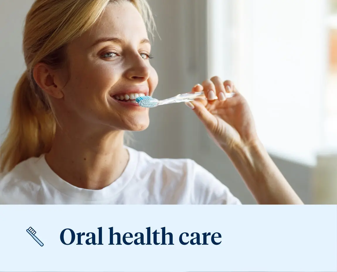 A woman wearing a white t-shirt is brushing her teeth while looking in a mirror with the text "Oral health care" at the bottom.