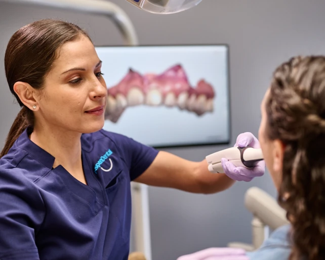 An Aspen Dental doctor examines a patient. 