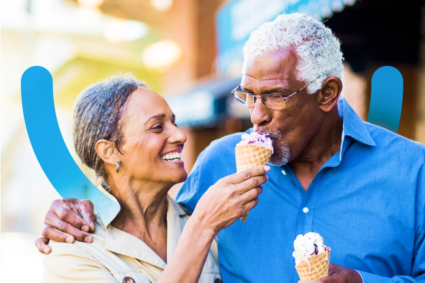 An older couple enjoys ice cream as they walk together. 