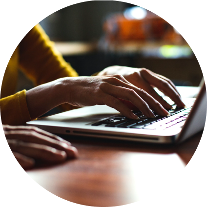 Hands type on a laptop keyboard. 