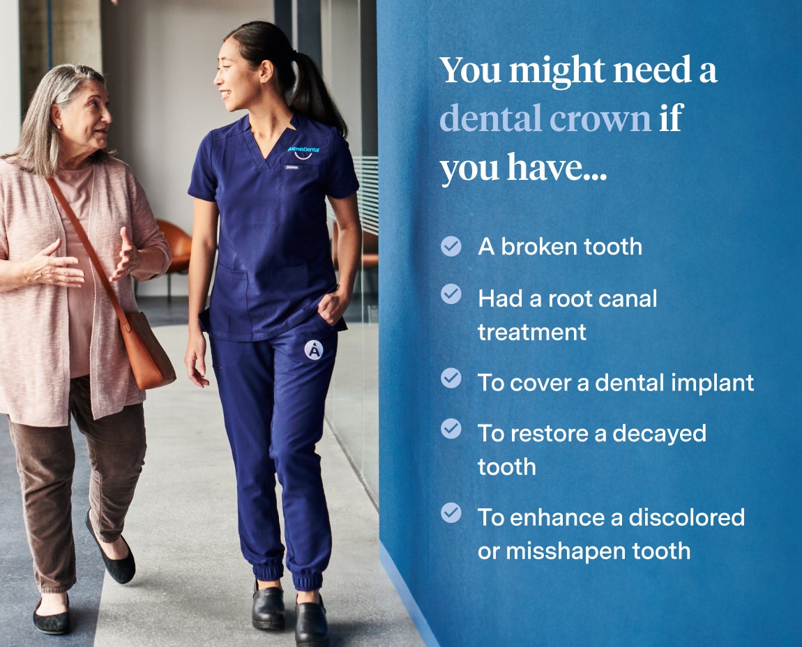 Aspen Dental professional in navy scrubs walking with an older woman while discussing reasons for needing a dental crown, including a broken tooth, root canal treatment, or dental implant coverage.