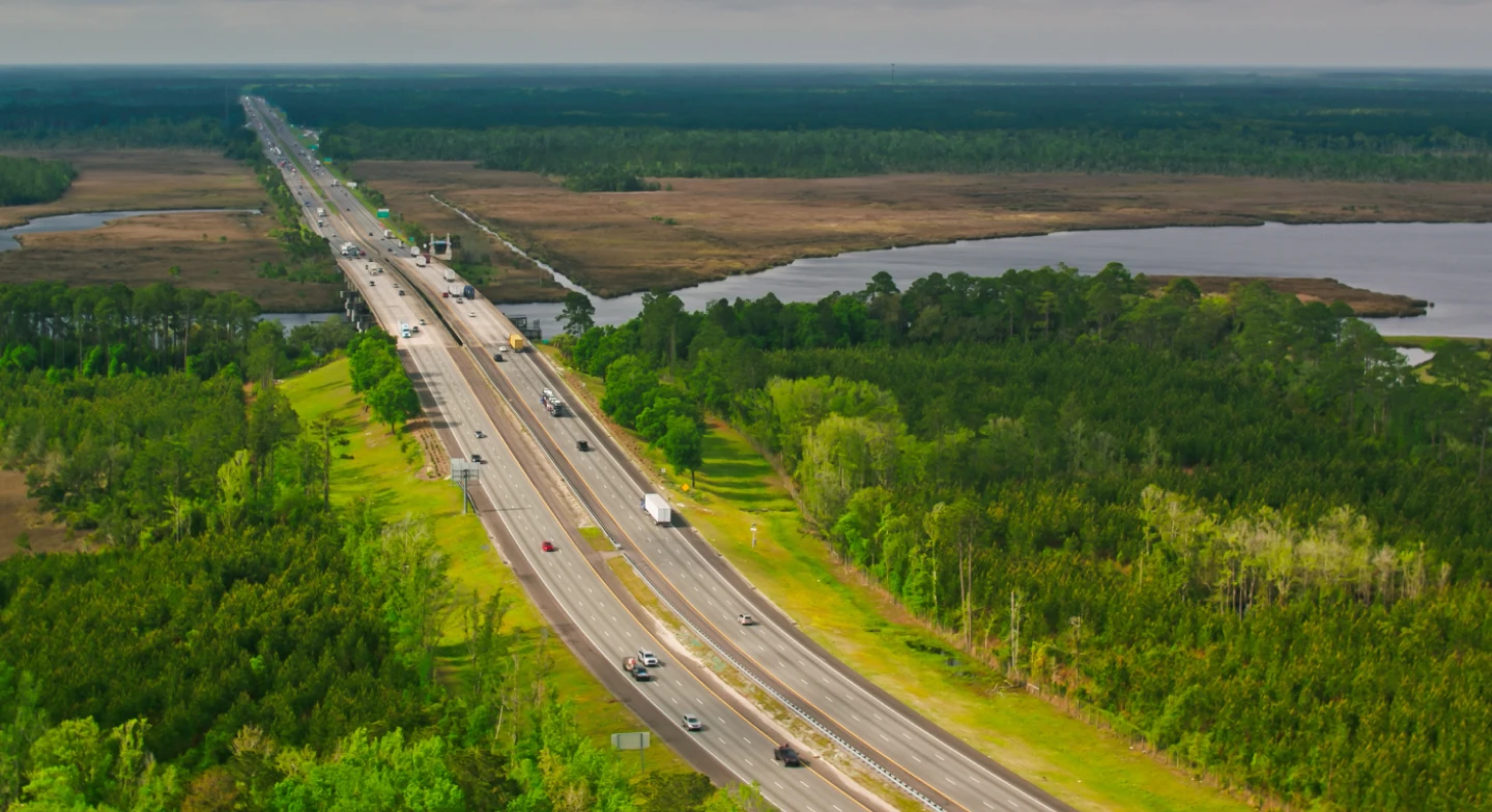 A view of a highway running through a rural and forested area near the Florida Georgia line