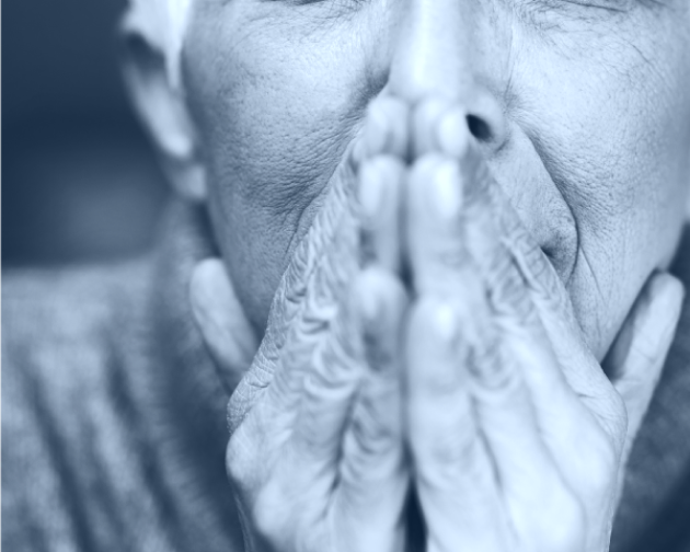  Black and white photo of closeup of a senior person's hands covering their mouth.