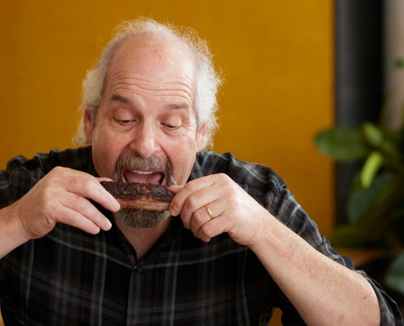 Senior man enjoying a meal comfortably, highlighting the benefits of dental care and oral health.