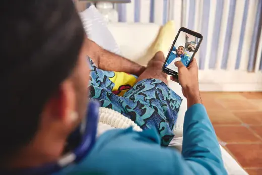 Motto Clear Aligners patient taking a selfie while lounging on a couch.