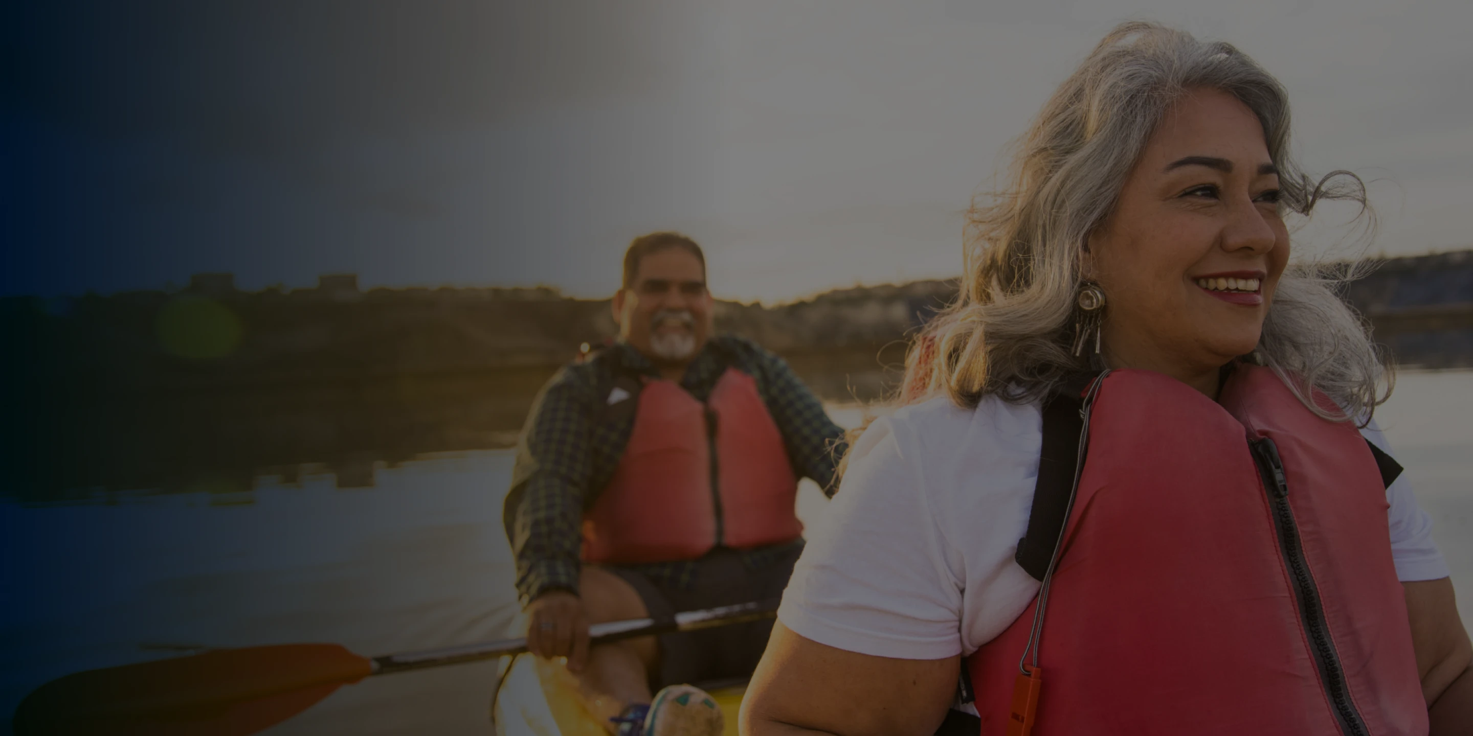 Smiling mature couple kayaking, promoting active lifestyle after dental implants.