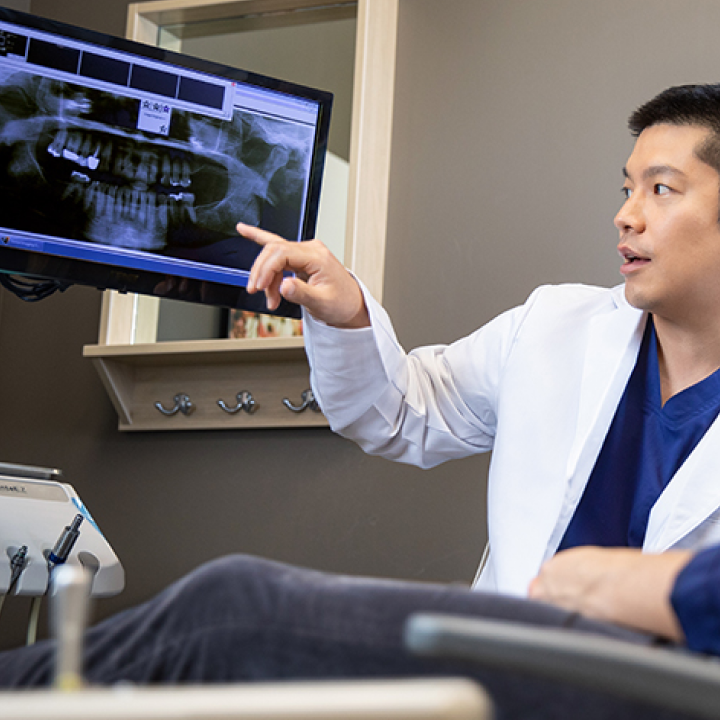 An Aspen Dental doctor explains X-rays to a patient. 