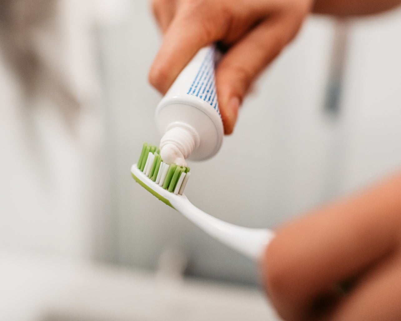 An image of a ClearChoice dental implant patient applying toothpaste to a toothbrush.