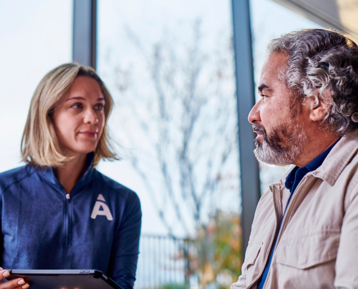 A dental professional at Aspen Dental discussing with a patient the factors that influence the lifespan of dental implants and their long-term care requirements.
