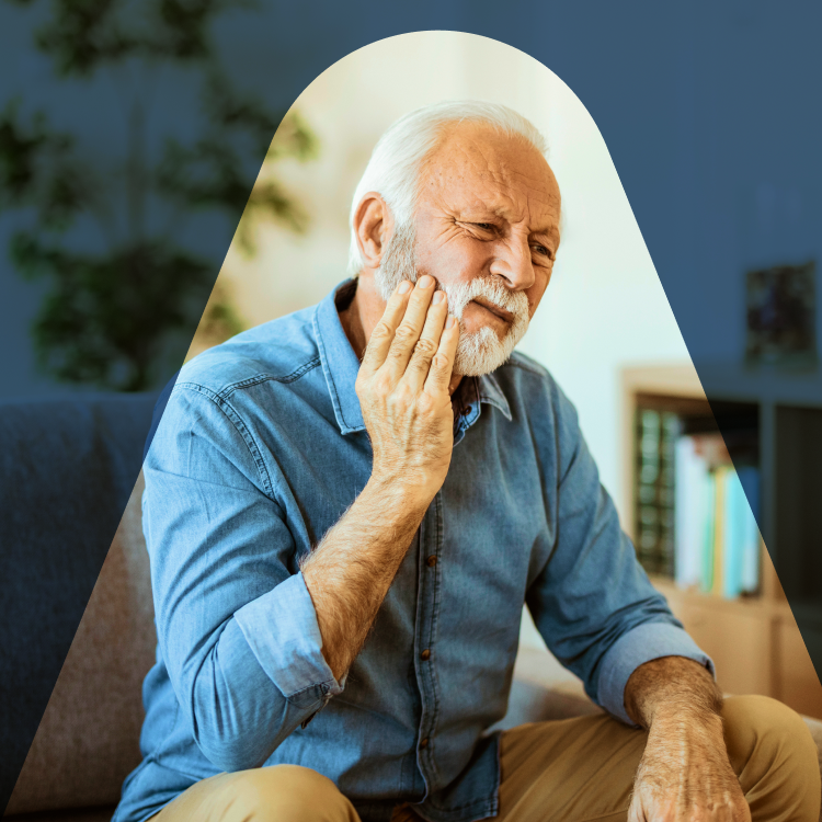 A man with a distressed expression, hand pressed to his cheek, wincing in apparent tooth pain, or other oral discomfort.