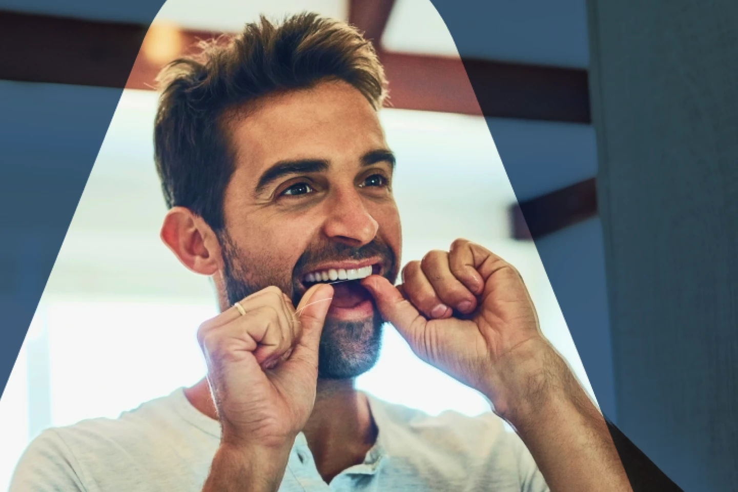 A man flossing his teeth to prevent various gum-related issues, including gingivitis with red, swollen gums, and periodontitis.