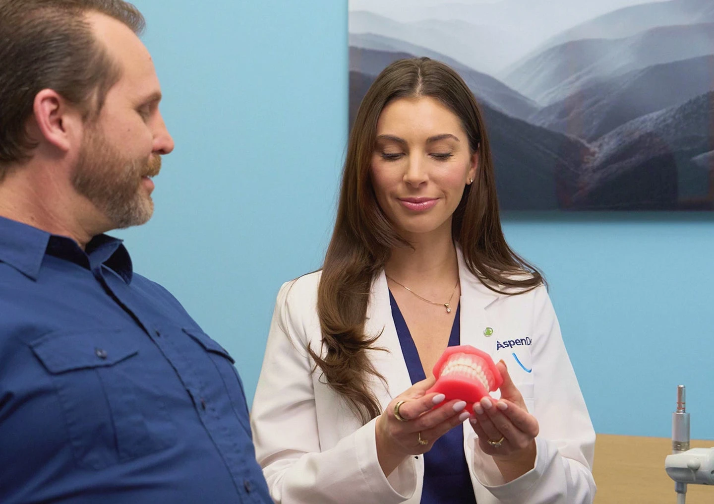 Aspen Dental provider warmly consulting with a patient about available dental services at a local office.