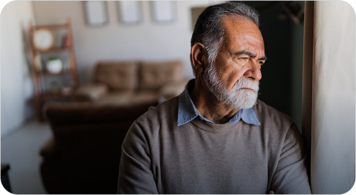 A man in a gray shirt suffering with dental pain and the negative impacts on his overall health.