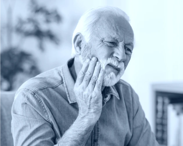 Black and white photo of a senior man grimacing from oral pain.