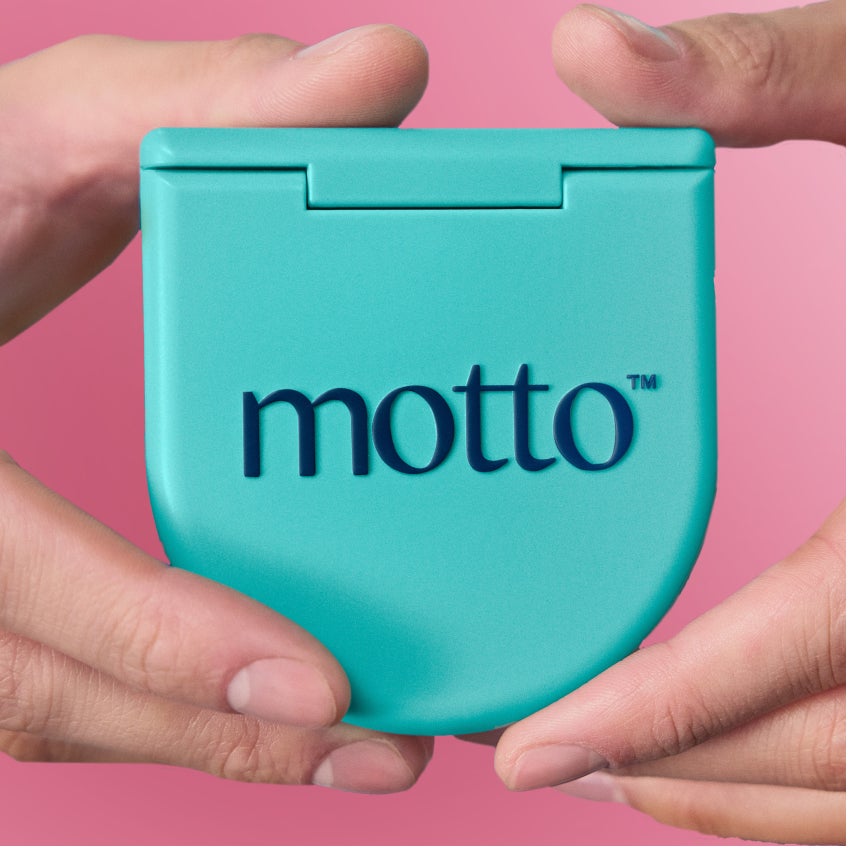 Hands hold a closed Motto clear aligners case. 