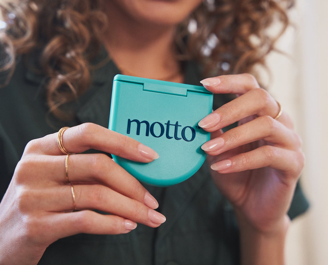Woman holding a Motto Clear Aligners branded case, showcasing the convenience and portability of Motto’s clear aligner system.