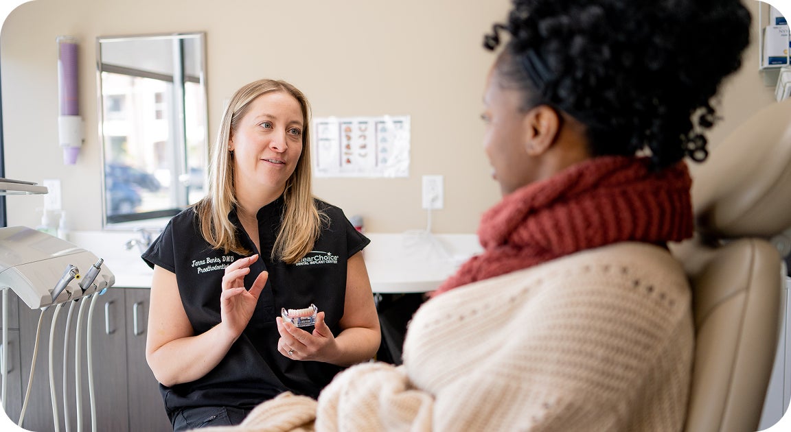A ClearChoice doctor discussing alternative treatment plans with her patient, who is ineligible for dental implants at the time due to osteoporosis and medications.