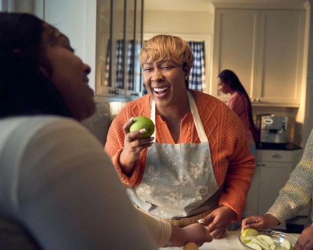 An image of a woman preparing a balanced diet of vegetables with her friends.