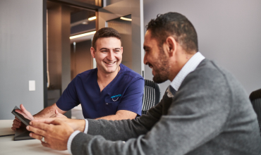 An Aspen Dental doctor consults with a patient. 