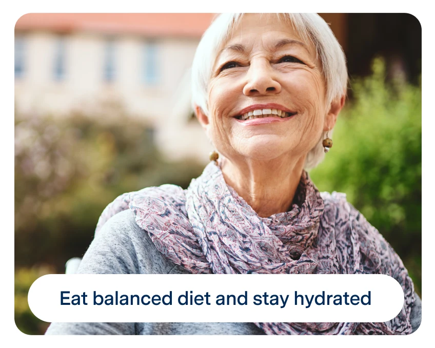 Elderly woman smiling outdoors, wearing a scarf. Text on the image reads, "Eat balanced diet and stay hydrated.