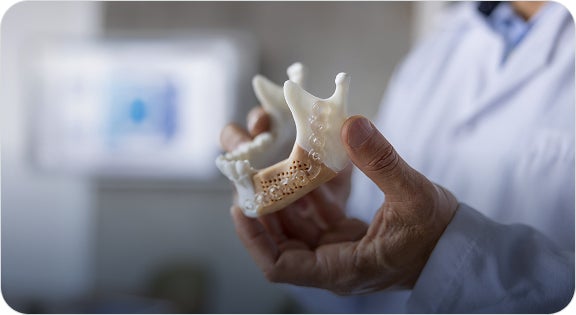 A ClearChoice oral & maxillofacial surgeon explaining a patient's scan results and explaining the need for a bone graft procedure during their initial consultation.