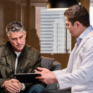 An Aspen Dental doctor consults with a patient.