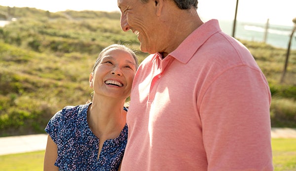 A man in a pink shirt stands next to a woman in a blue shirt