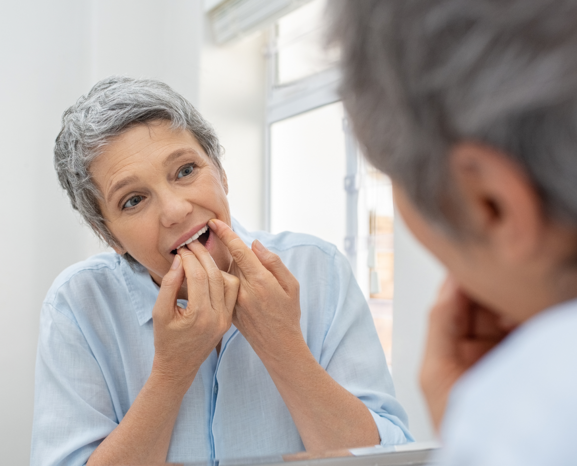A woman sits in a dental chair with a worried expression, likely discussing plaque-related symptoms or gum discomfort with her dentist.