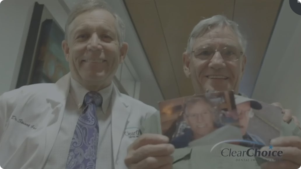 Two doctors holding up a picture with ClearChoice written on the bottom

