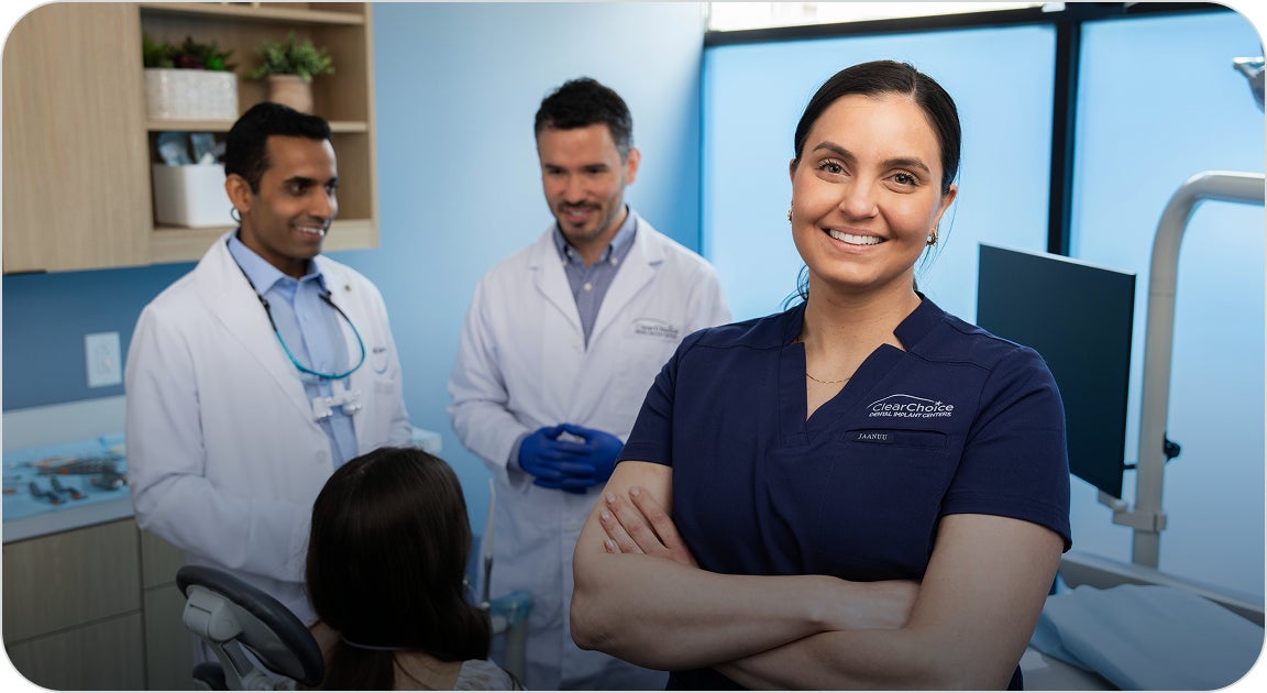 A ClearChoice prosthodontist working with an oral surgeon and a lab technician on planning and walking a patient through their dental implant treatment plan.