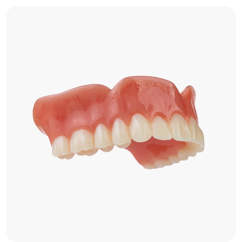 Side view of a classic denture featuring pink gums and natural-looking teeth, provided by Aspen Dental.