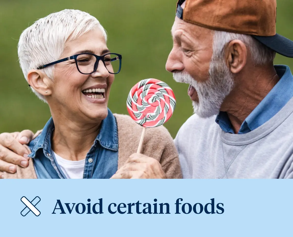 Two smiling elderly individuals, one holding a large colorful lollipop, with the text "Avoid certain foods" at the bottom.