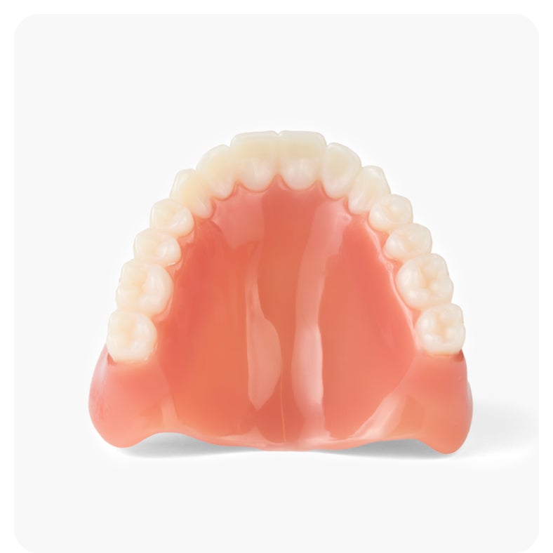 Top view of a classic upper denture with pink gums and white teeth, provided by Aspen Dental.