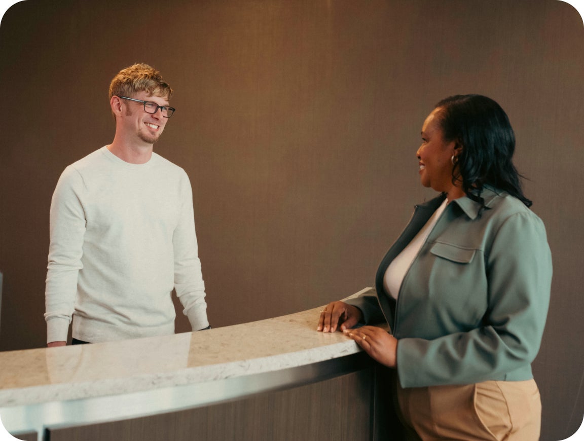 A patient speaks with a ClearChoice Dental Implant Center team member at the front desk, discussing potential discounts and third-party financing options to help make dental implant treatment more manageable.