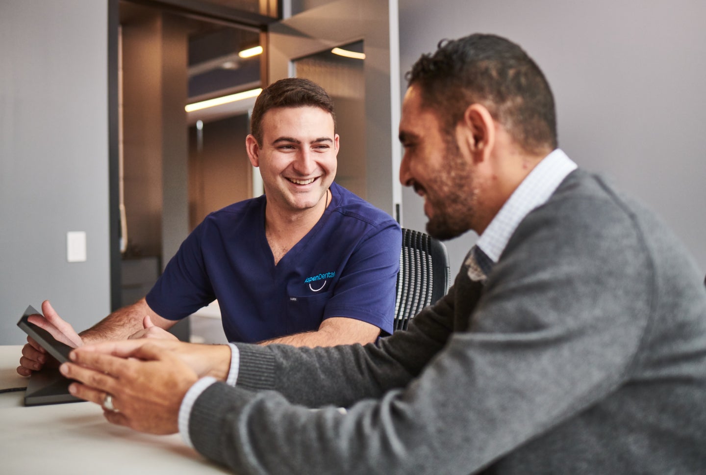 An Aspen Dental doctor smiles with a patient. 