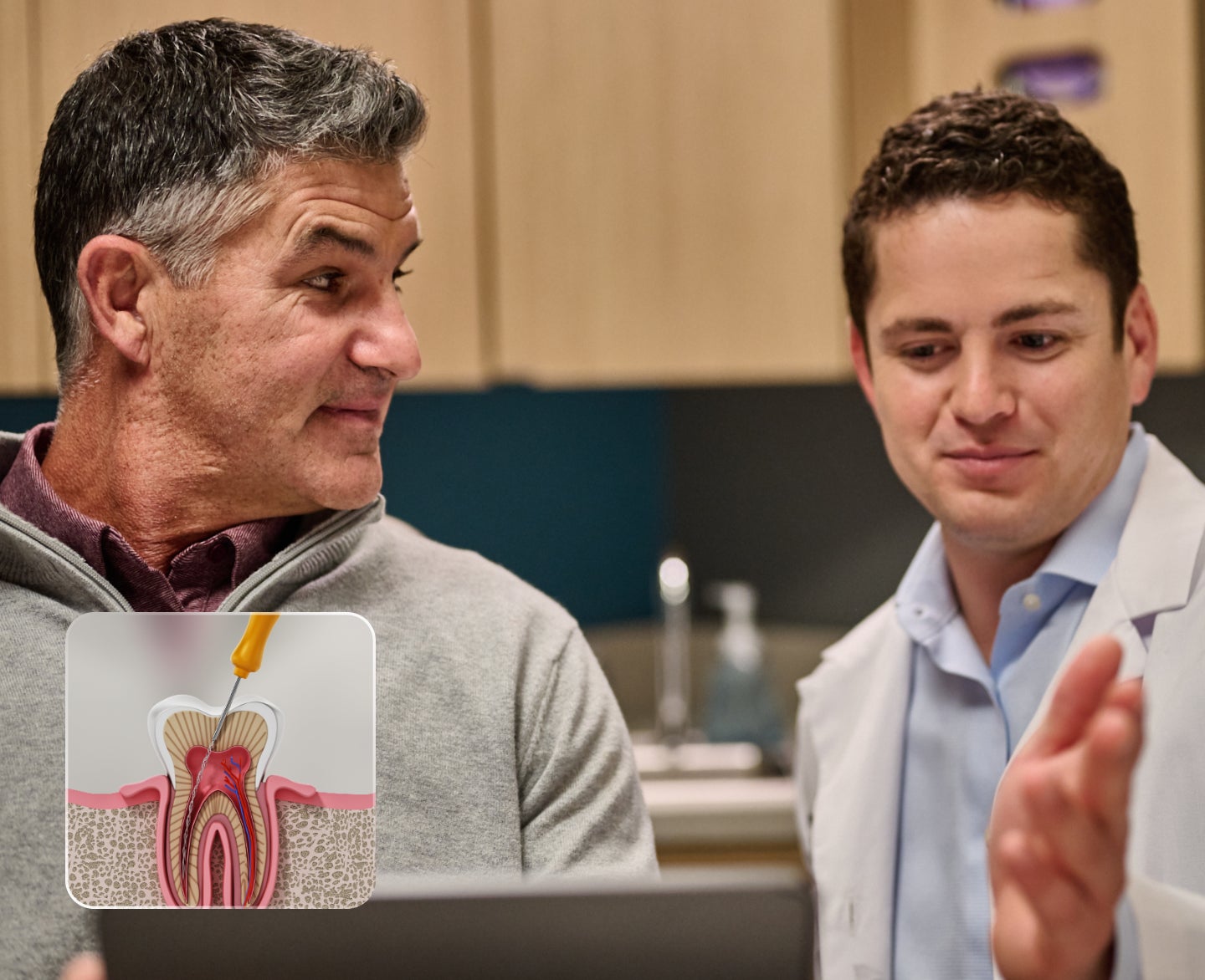 A dentist in a white coat and a man discuss information displayed on a tablet in a medical office.