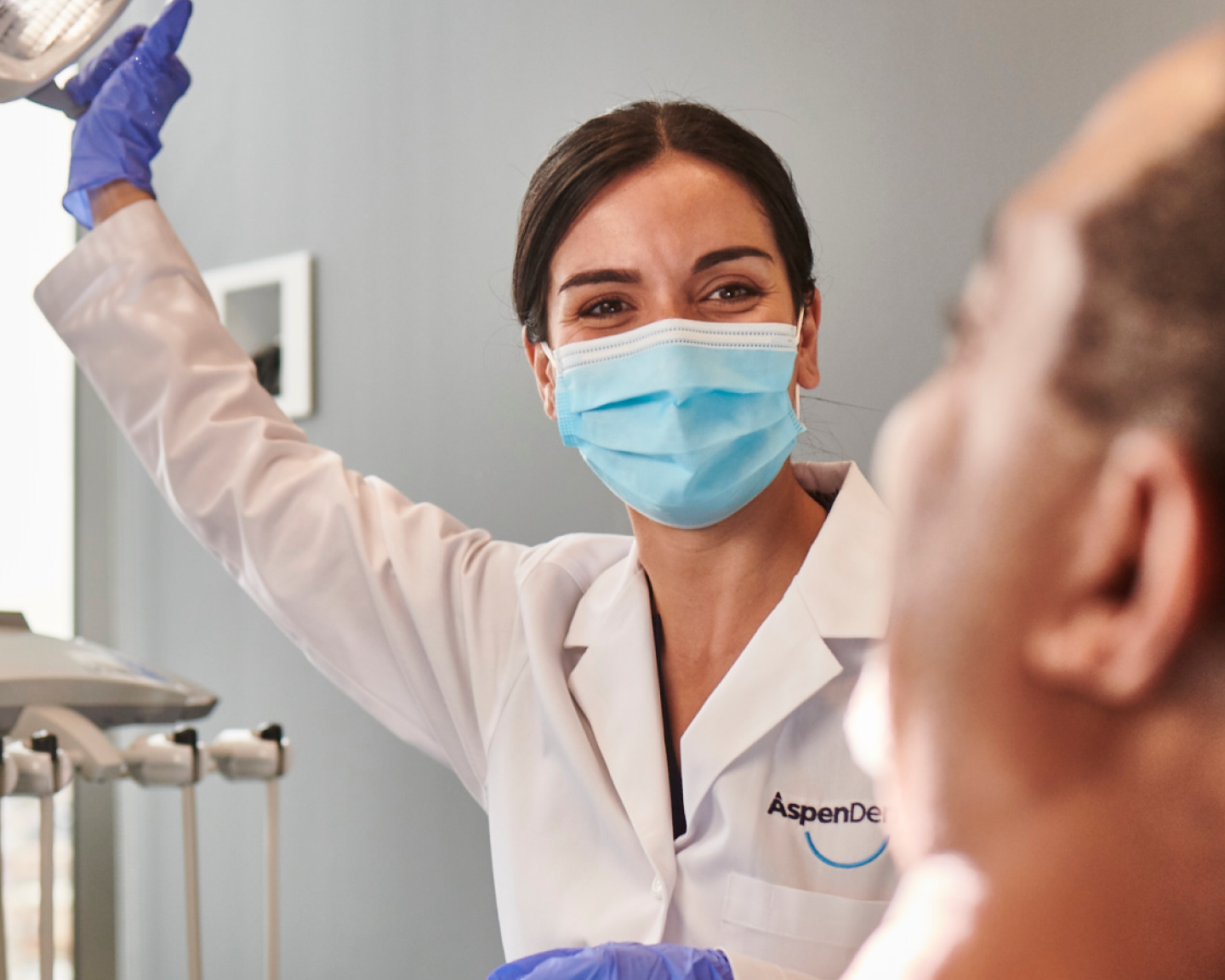 An Aspen Dental doctor prepares for a dental exam. 
