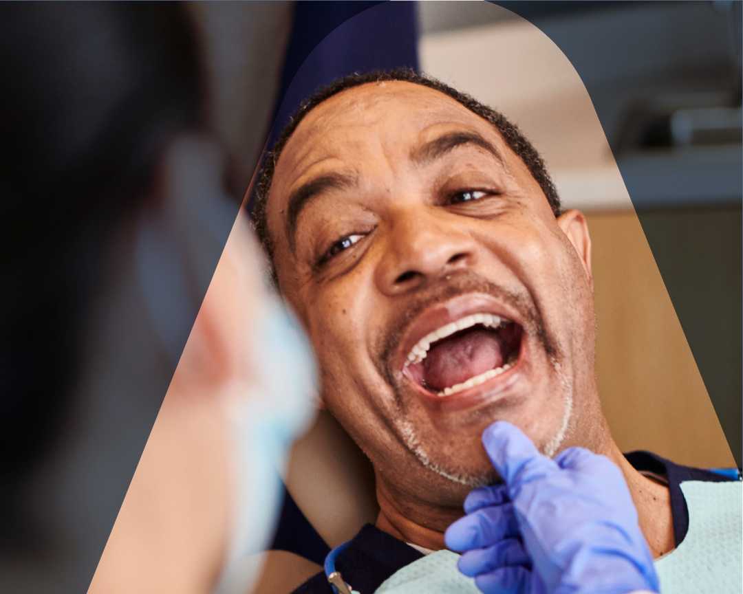 Aspen Dental dentist performing a dental checkup on a patient's teeth, ensuring his oral hygiene and maintaining his dental health.