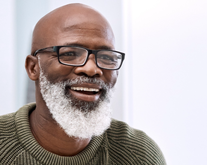 Aspen Dental dentures patient smiling in mirror.