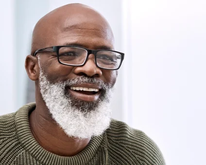 Aspen Dental dentures patient smiling in mirror.