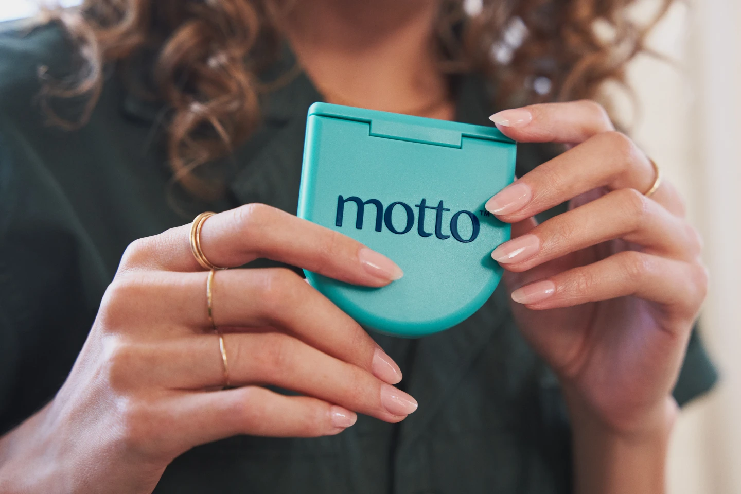A person holds a Motto clear aligners case. 